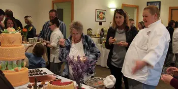 Baking chef at table with two women 