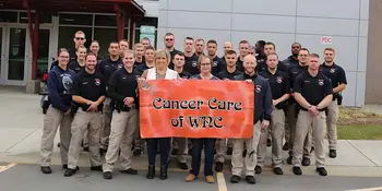 28 students and two women holding a banner reading Cancer Care of WNC