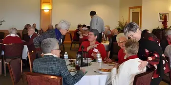 Men and women in a dining room eating brunch. 