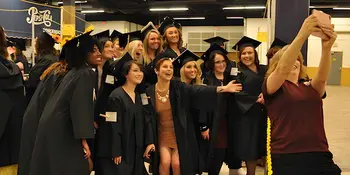 Students taking group selfie at commencement