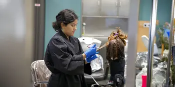 A woman working on a head of hair