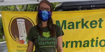 Woman wearing a mask in farmers market booth