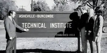 Man with three students beside A-B Tech sign in 1960s