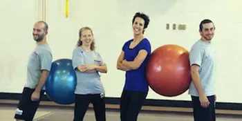 Four people with two large playground balls