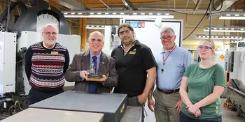 Dennis King holding a miniature engine lathe with 4 other people
