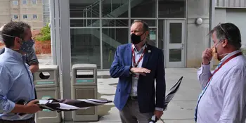 Three men wearing masks and talking