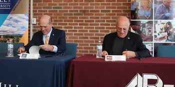 Dennis King and Tony Floyd signing a document