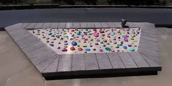 Rocks with positive messages laid in sand pit.
