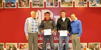 Gentry Heating President and three Gentry Heating Scholarship recipients standing in front of a wall