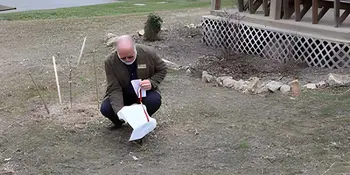 Vernon Daughterty taking the cover off of a plaque.